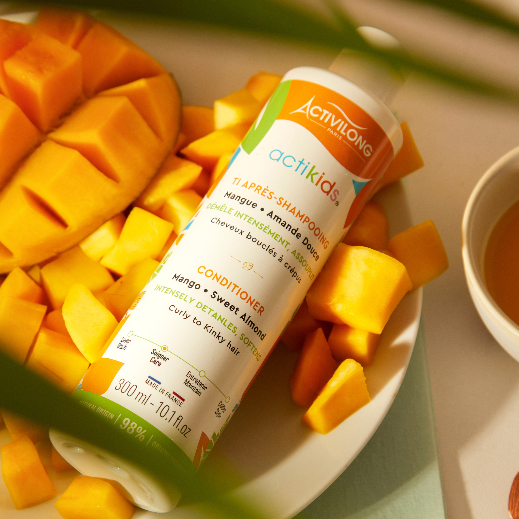 ACTIVILONG ACTIKIDS Conditioner Après-Shampoing 250ml bottle by ABS France Wholesale with mango pieces on a plate