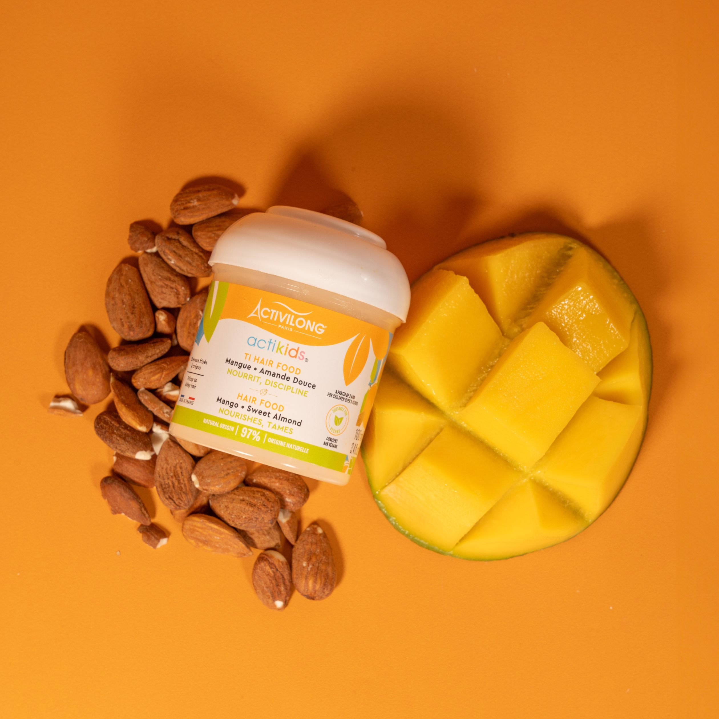 ACTIVILONG ACTIKIDS Ti-Hair Food 100ml by ABS France Wholesale with almonds and a sliced mango on an orange background