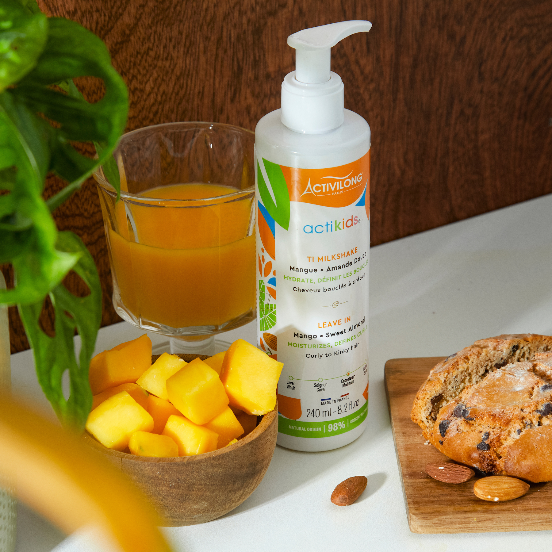 ACTIVILONG ACTIKIDS Ti Milkshake Leave-In 250ml bottle by ABS France Wholesale of termitaire with a glass of orange juice, bowl of mangoes, and bread on a white surface.