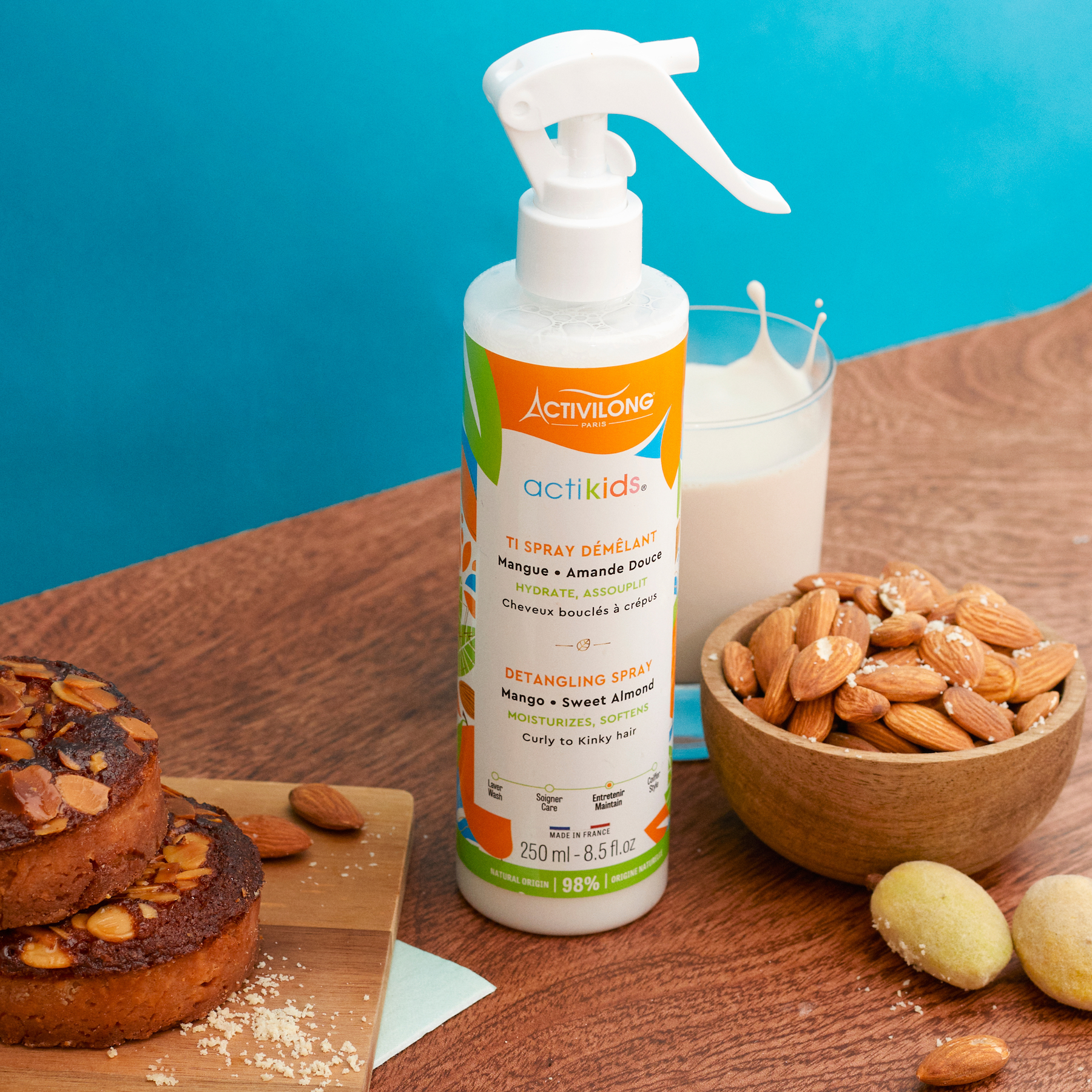 ACTIVILONG ACTIKIDS Ti Spray Démêlant 250ml bottle by ABS France Wholesale on a wooden table with almonds and a glass of milk.