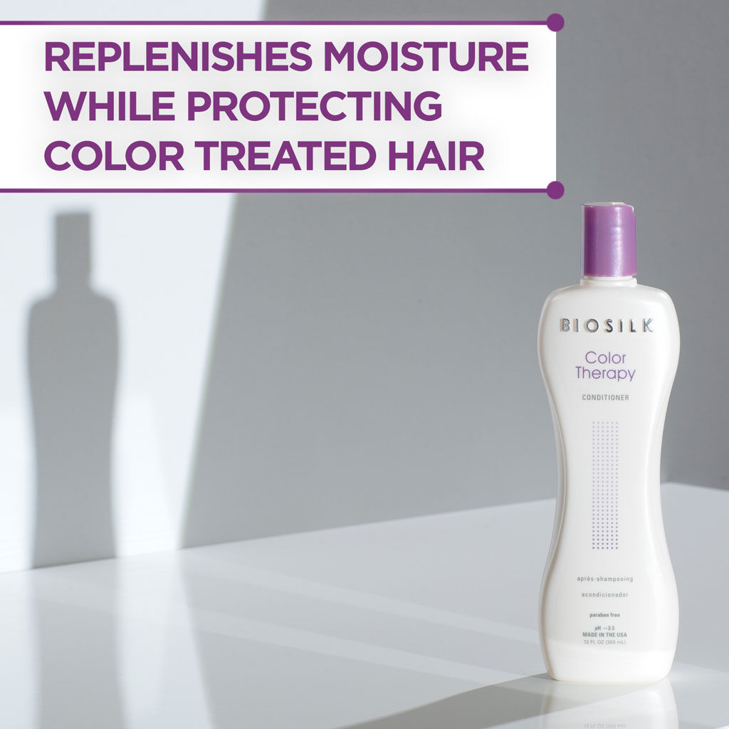 Biosilk Color Therapy Conditioner bottle on a white reflective surface with a gray background and a text banner at the top reading 'REPLENISHES MOISTURE WHILE PROTECTING COLOR TREATED HAIR'.