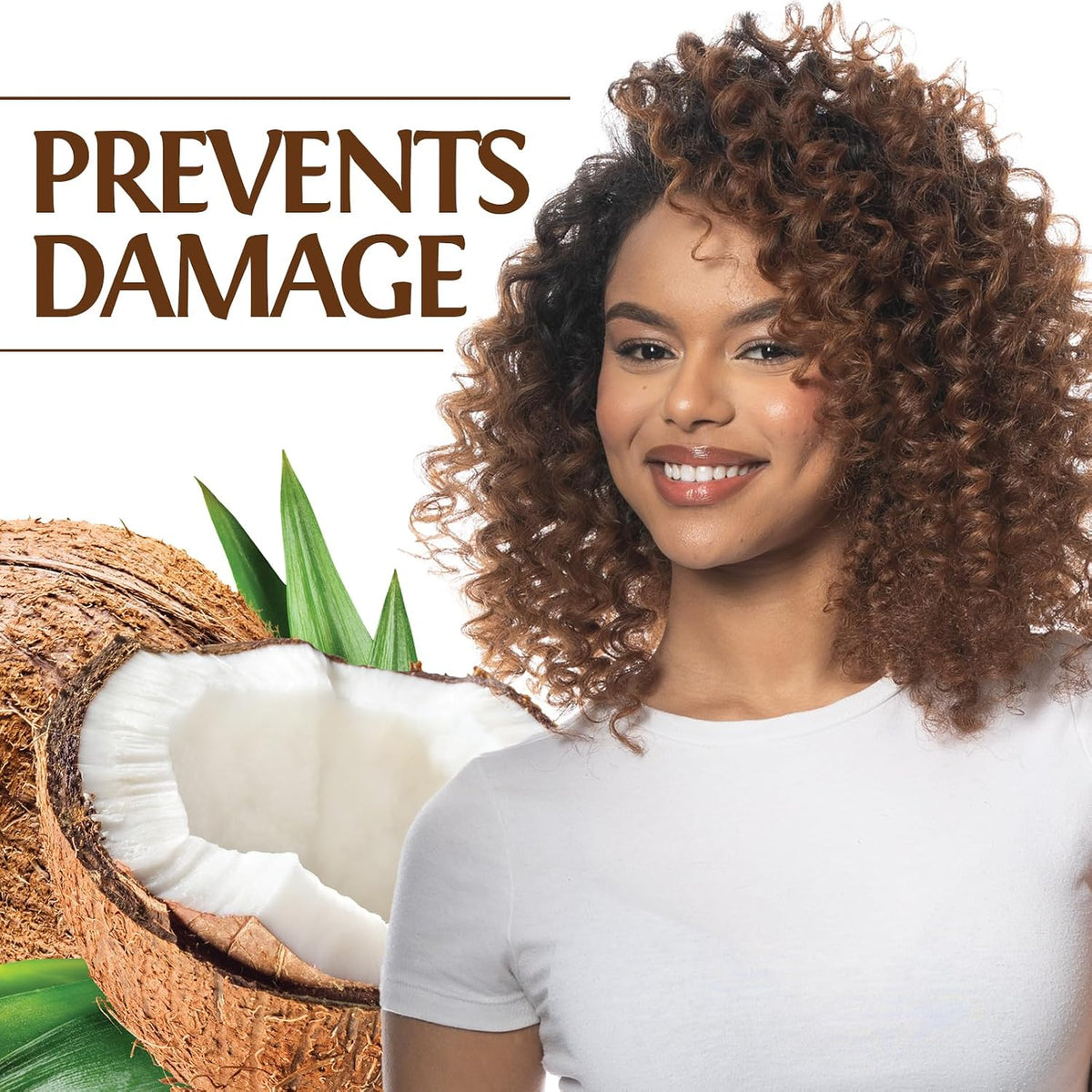 A smiling woman with voluminous curly brown hair wearing a white t-shirt, positioned next to a halved coconut with green leaves. The text 'PREVENTS DAMAGE' is displayed in brown at the top left against a white background.