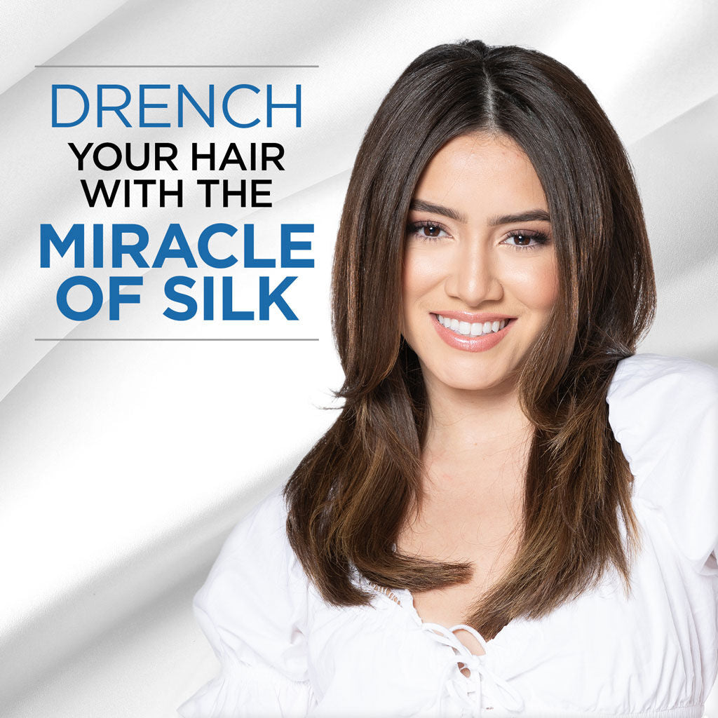 Woman with long brown hair smiling, with text 'Drench your hair with the miracle of silk' on a white background.