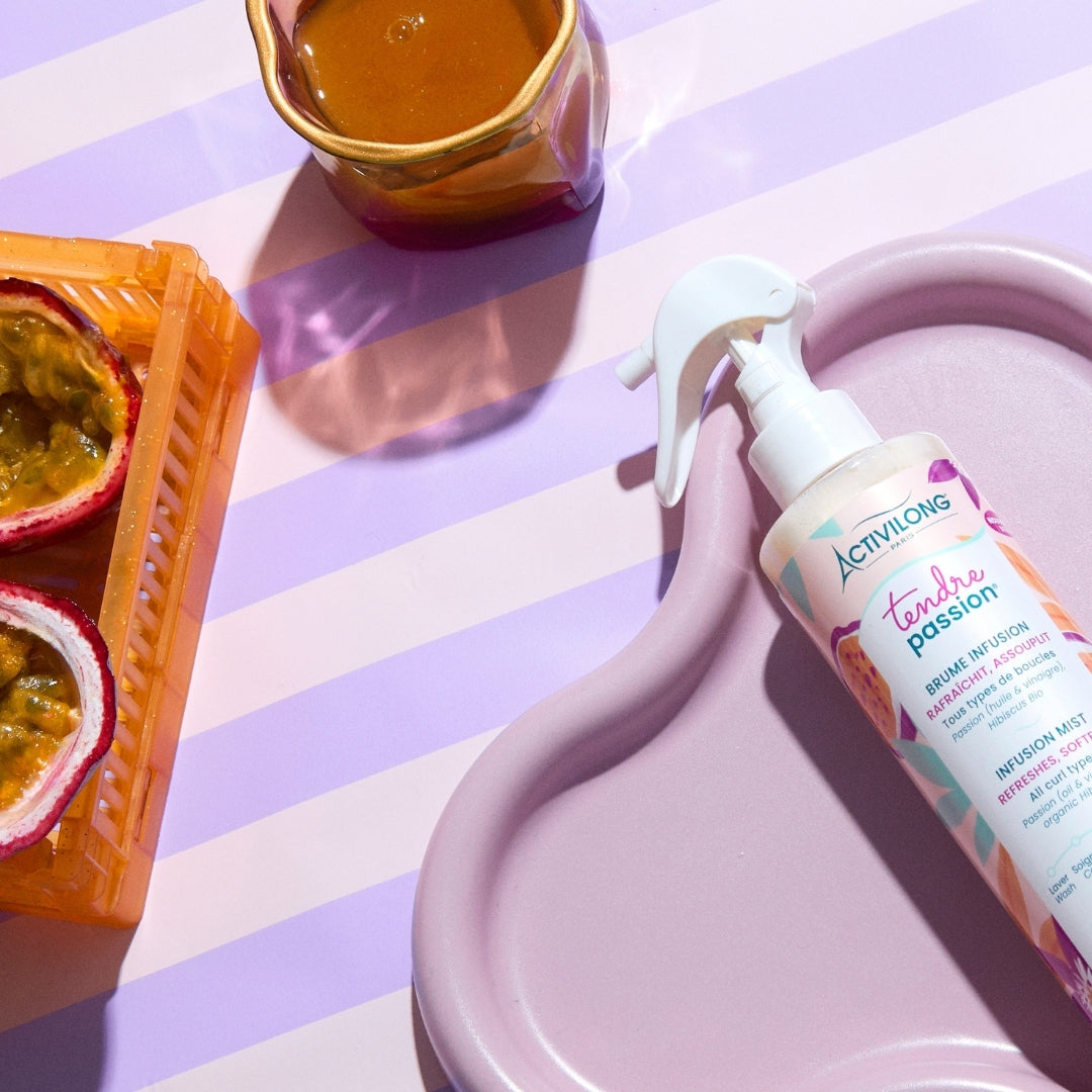 ACTIVILONG TENDRE PASSION Brume Infusion 250ml spray bottle by ABS France Wholesale on a striped surface with passion fruit and honey.