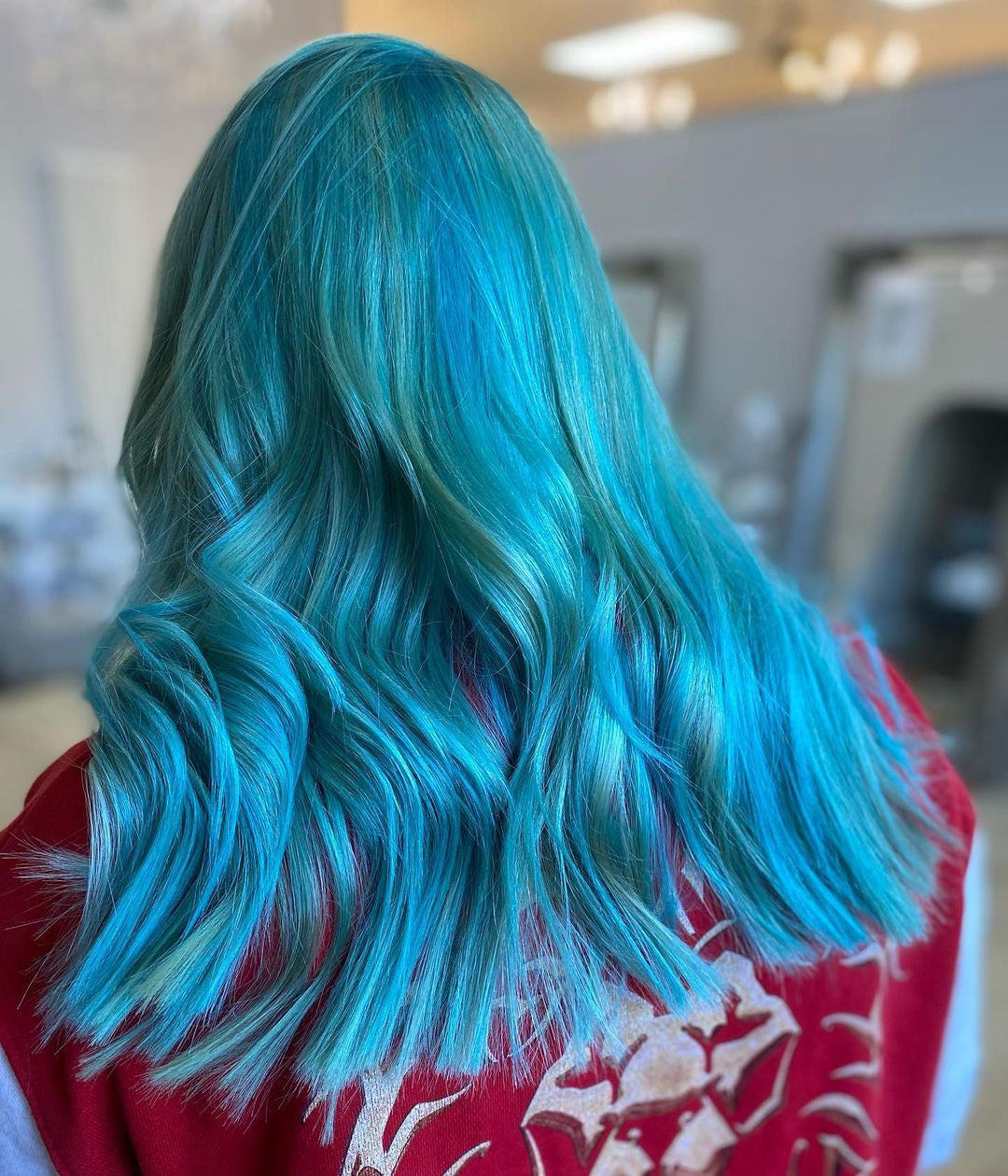 Crazy Color's Person with vibrant blue hair in a salon setting by ABS France Wholesale 