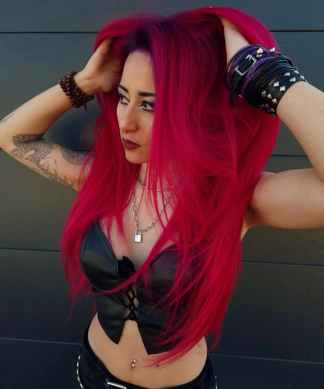 Crazy Color's Person with vibrant red hair and tattoos posing against a dark background by ABS France Wholesale