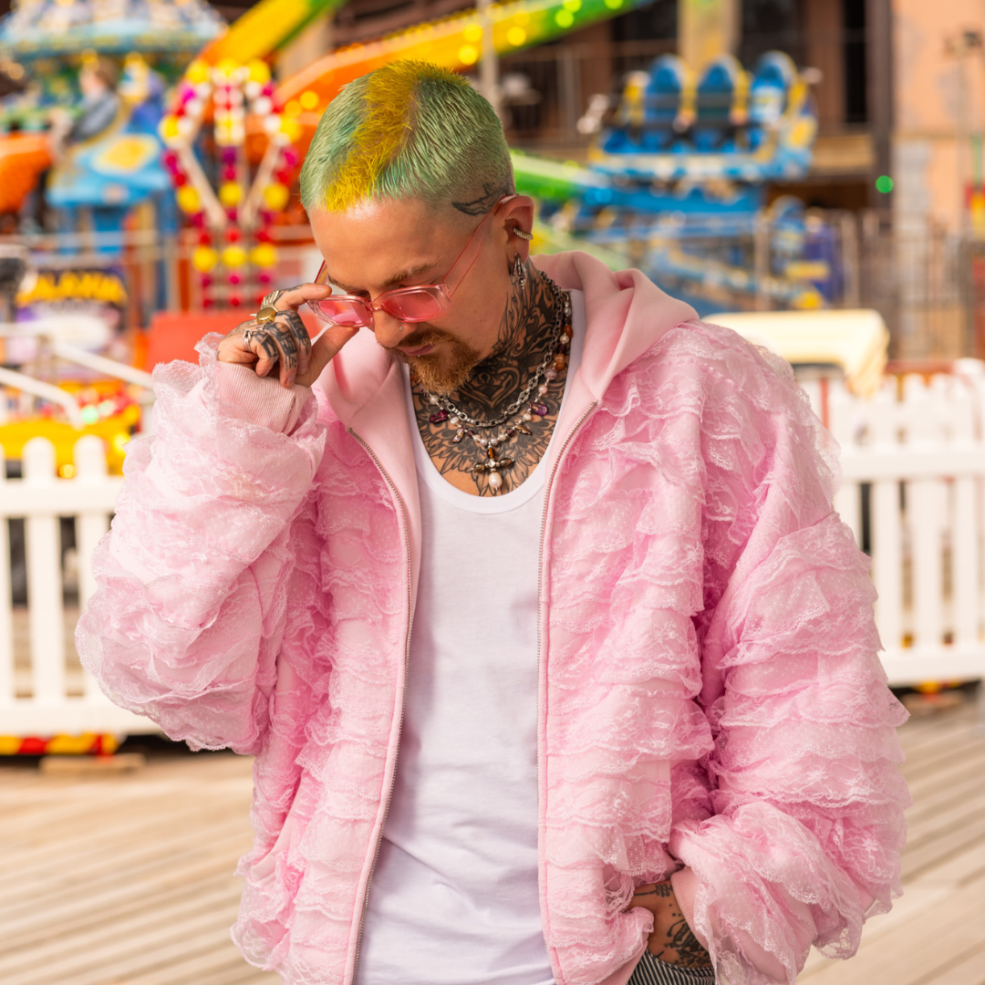 Crazy Color's person wearing a pink jacket and sunglasses at an amusement park by ABS France Wholesale