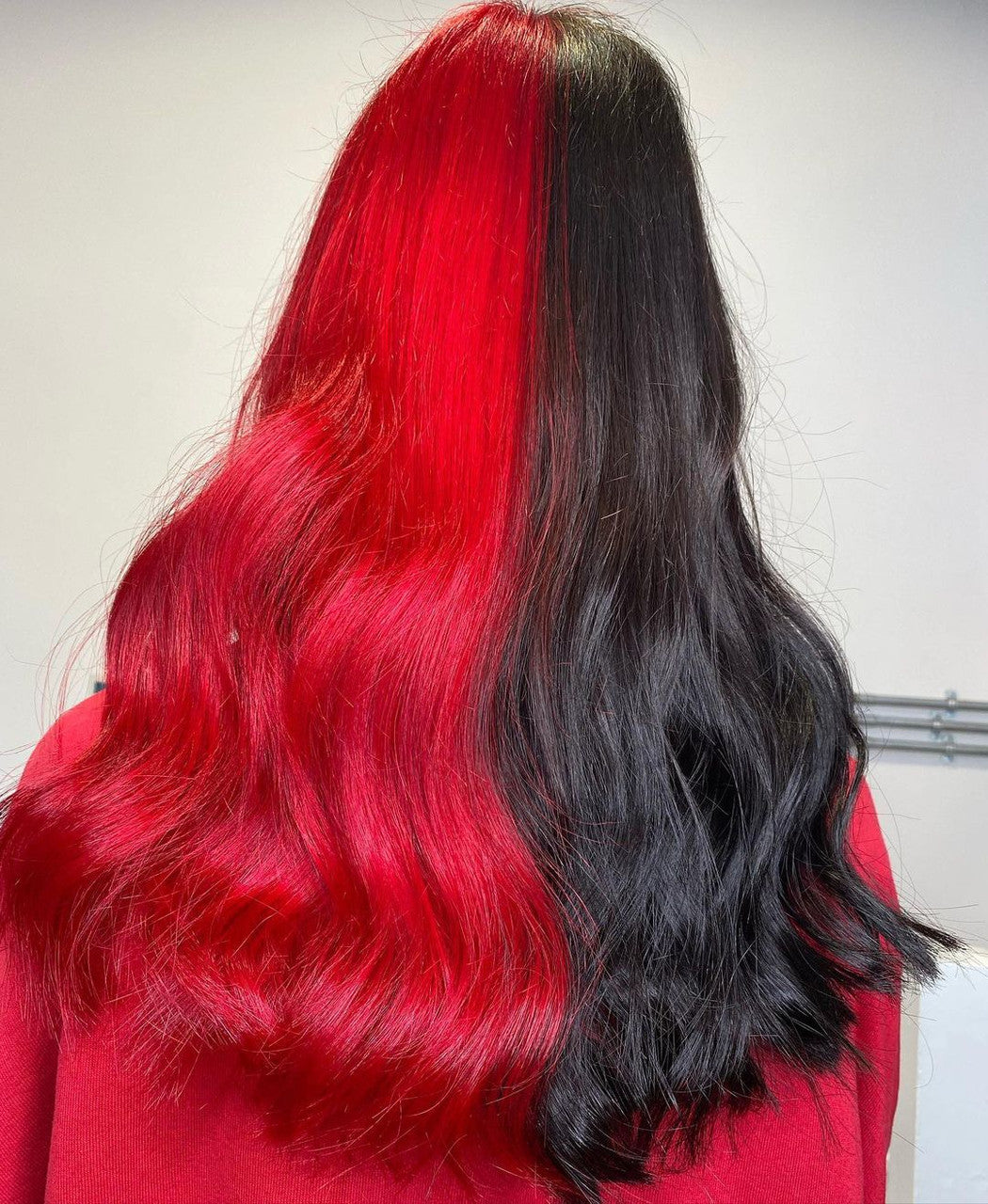 Crazy Color's Person with red and black hair color gradient on a plain background by ABS France Wholesale