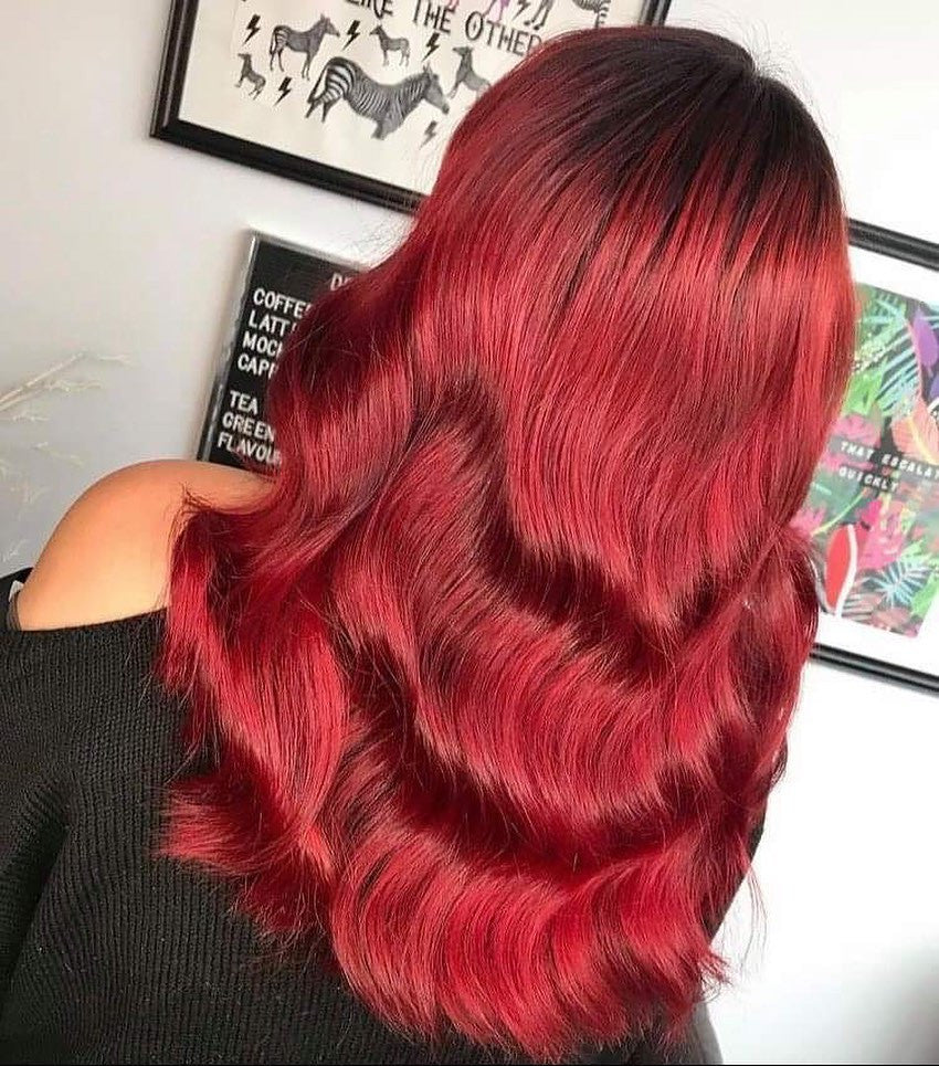 Crazy Color's person Red hair with wavy texture in front of a white wall with framed pictures by ABS France Wholesale
