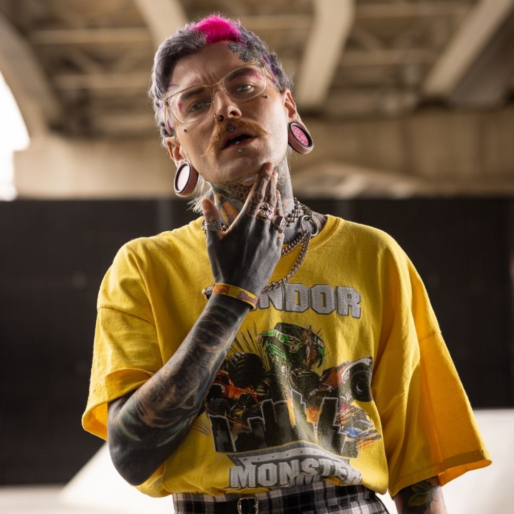 Crazy Color's Person wearing a yellow t-shirt with graphic design, standing under a bridge by ABS France Wholesale