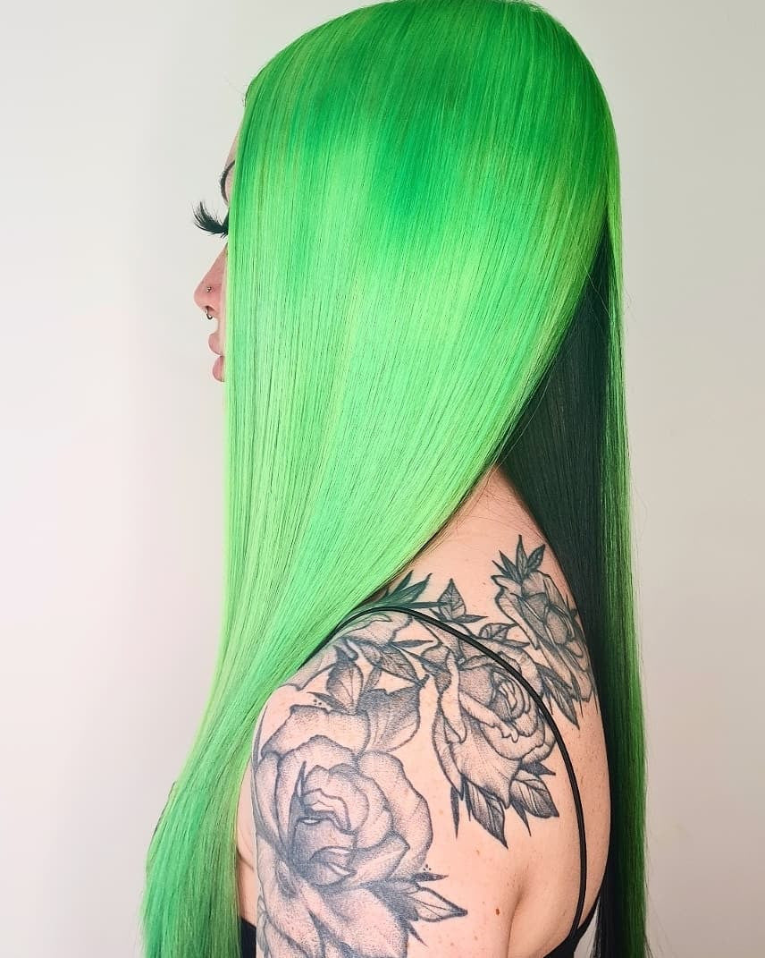 Crazy Color's Person with bright green hair and tattoos on shoulder against a plain background by ABS France Wholesale