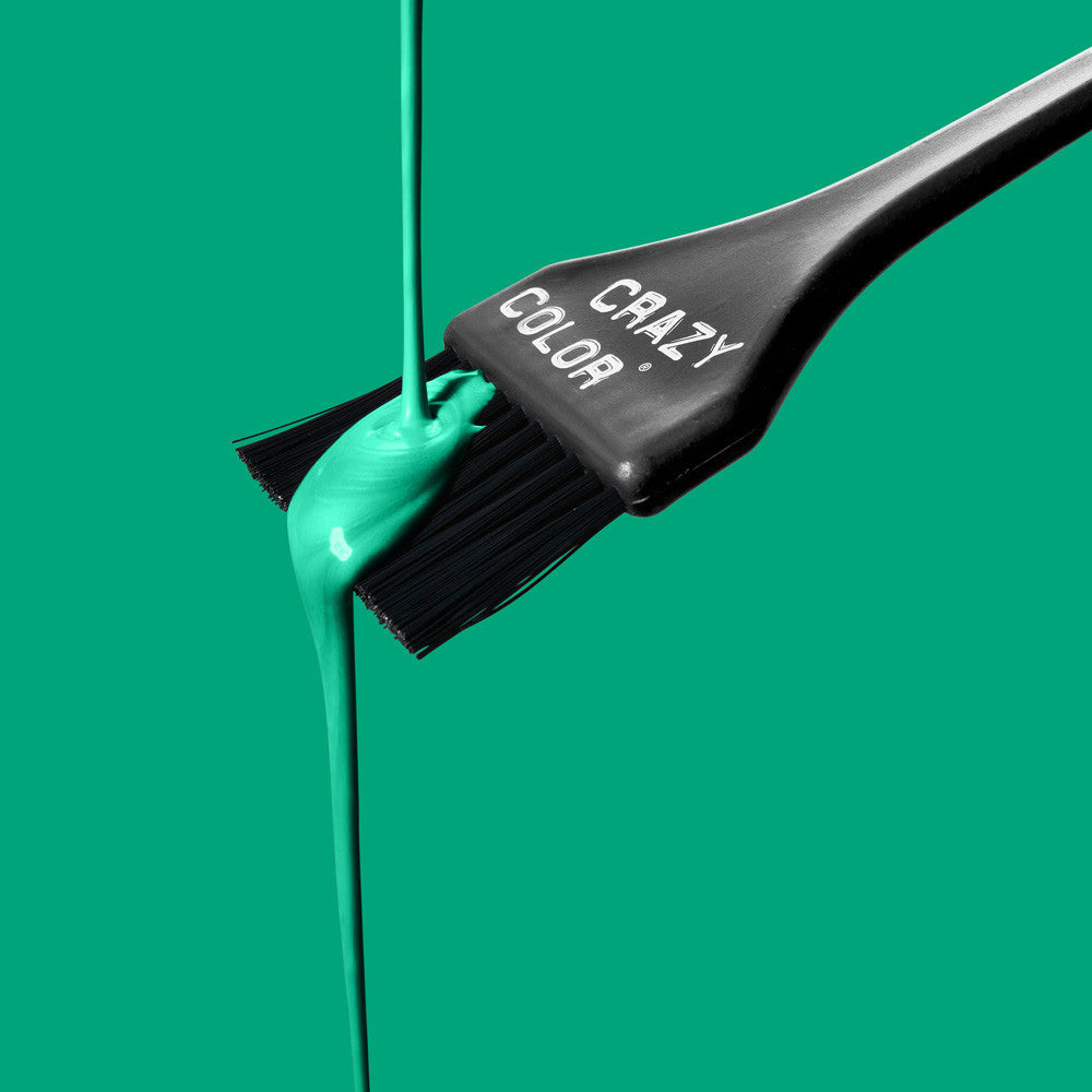 Black Hair dye brush with Crazy Color's emerald green color dripping from it on a green background by ABS France Wholesale