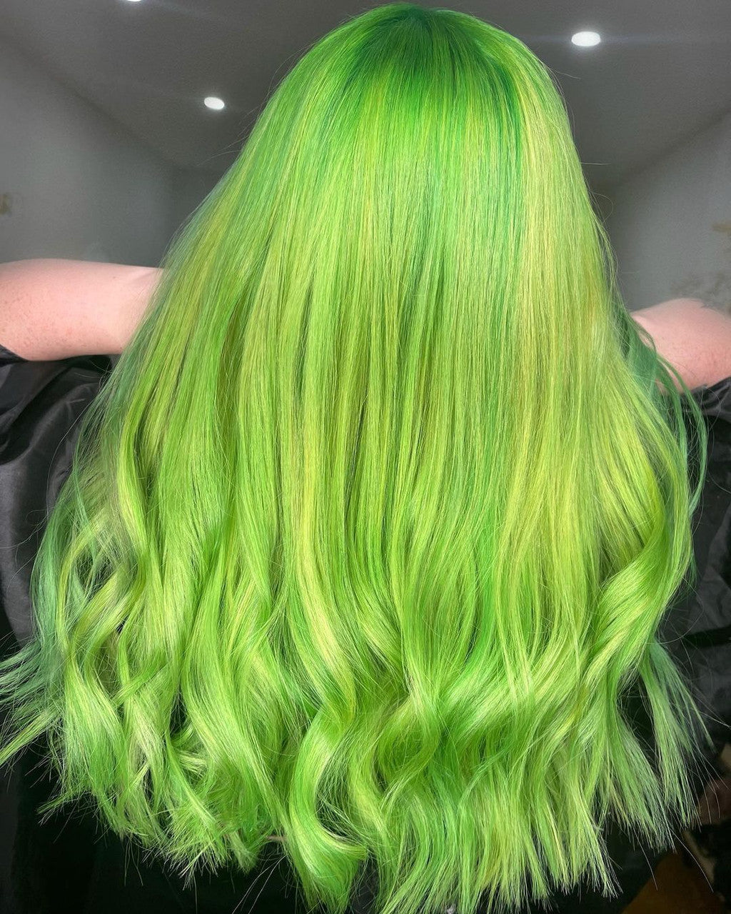 Crazy Color's Person with vibrant green hair in a salon setting by ABS France Wholesale