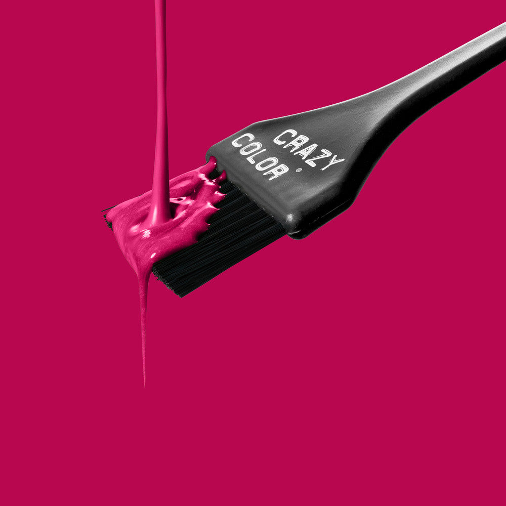 Black hair dye brush with Crazy Color's aubergine dye on a bright pink background by ABS France Wholesale