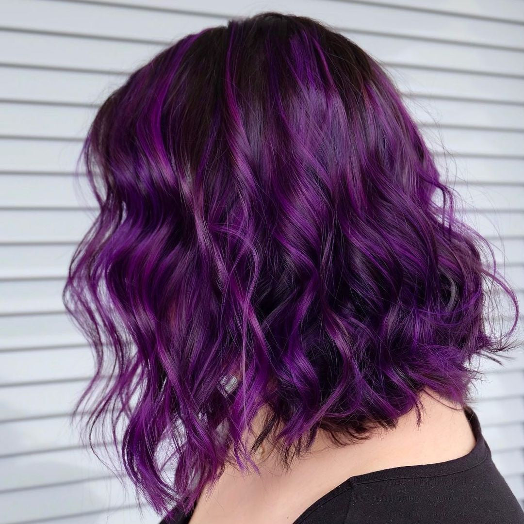 Crazy Color's Person with wavy purple hair against a neutral background by ABS france Wholesale