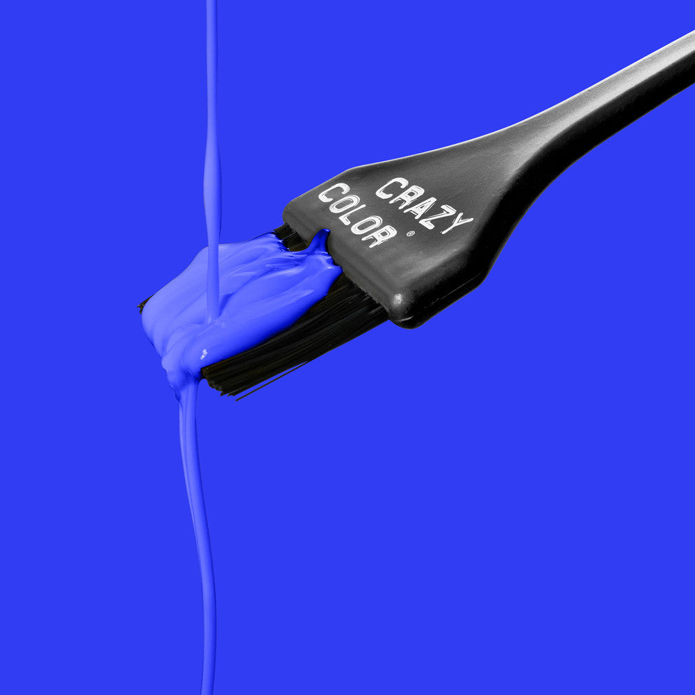 Blue paint being applied with a brush labeled 'Crazy Color' on a blue background by ABS France Wholesale