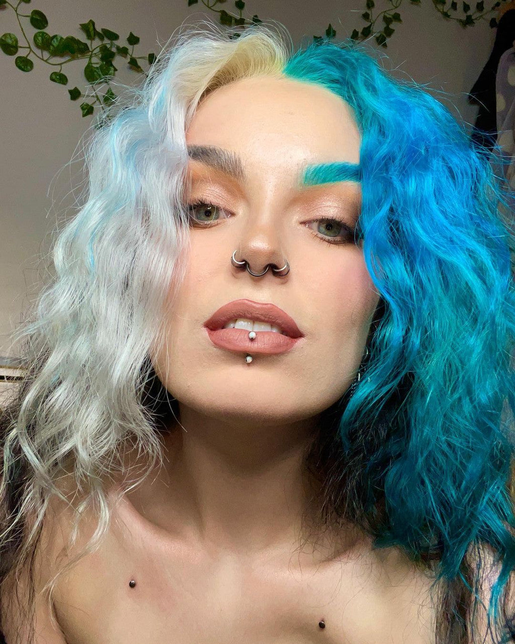 Crazy Color's Person with half white and half blue hair, wearing a nose ring and lip piercings by ABS France Wholesale
