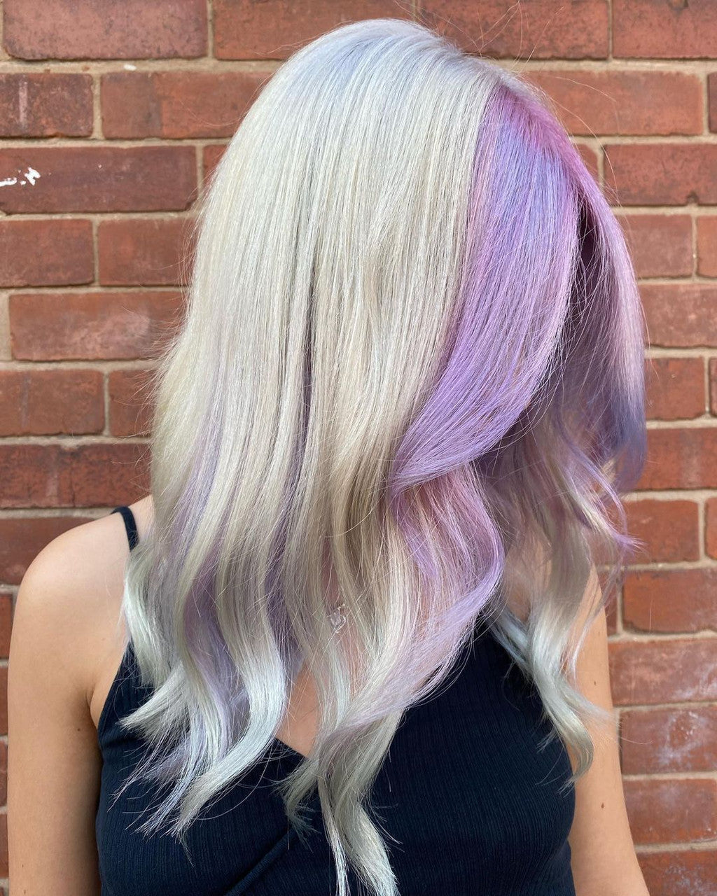Crazy Color's Person with light blonde and purple hair against a brick wall by ABS France Wholesale