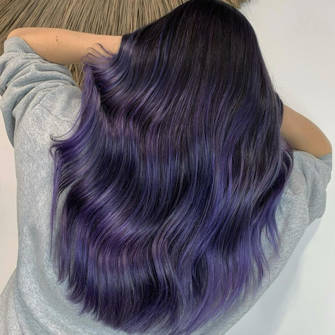 Crazy Color's Person with purple hair styled in loose waves, wearing a light gray long-sleeve shirt by ABS France Wholesale