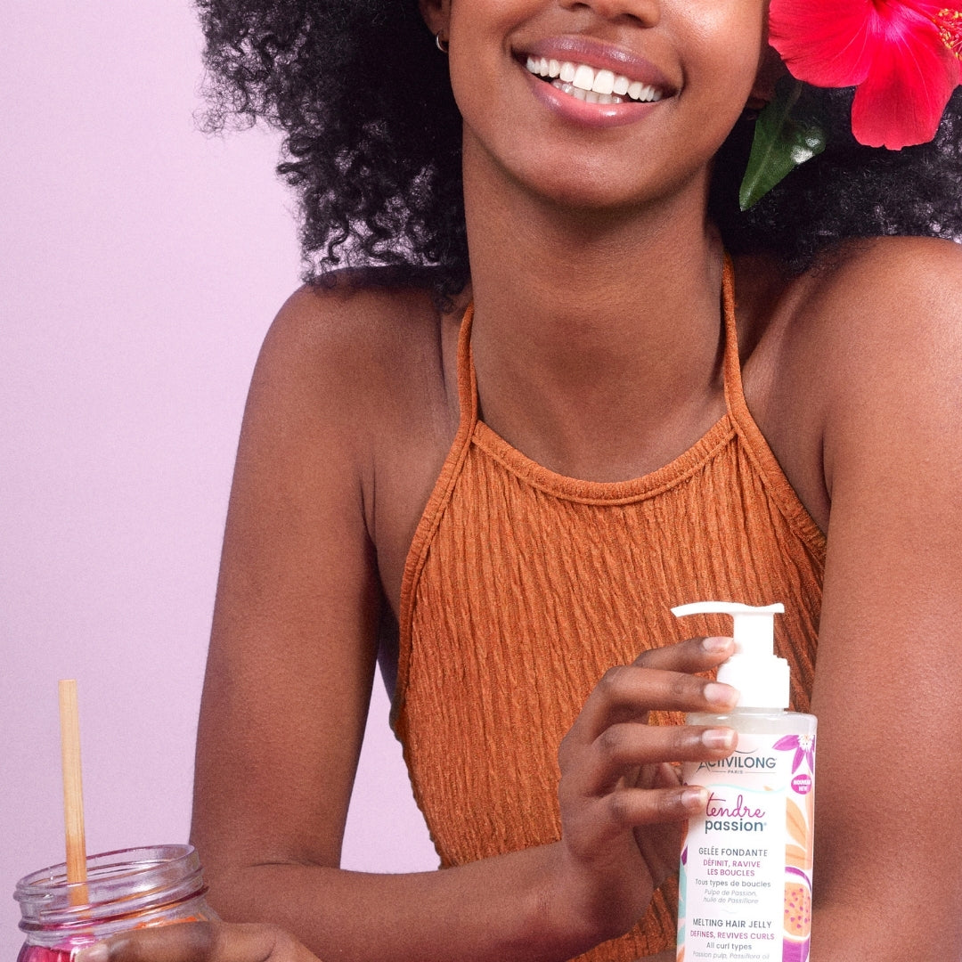 Woman holding a Bottle of ACTIVILONG TENDRE PASSION Gelée Fondante 260ml by ABS France Wholesale with a pink background