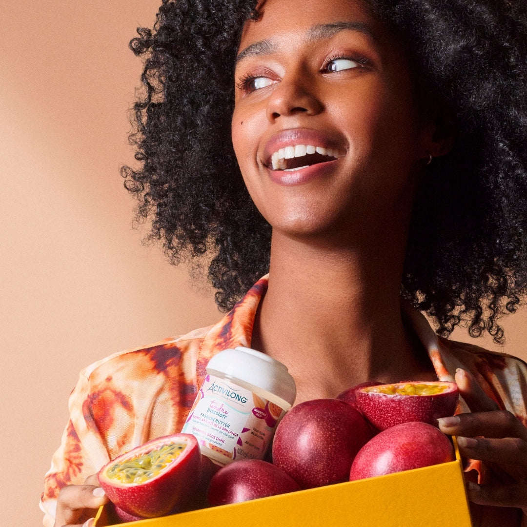 Woman holding a box of fruits and an ACTIVILONG TENDRE PASSION Passion Butter 100ml Container by ABS France Wholesale against a beige background