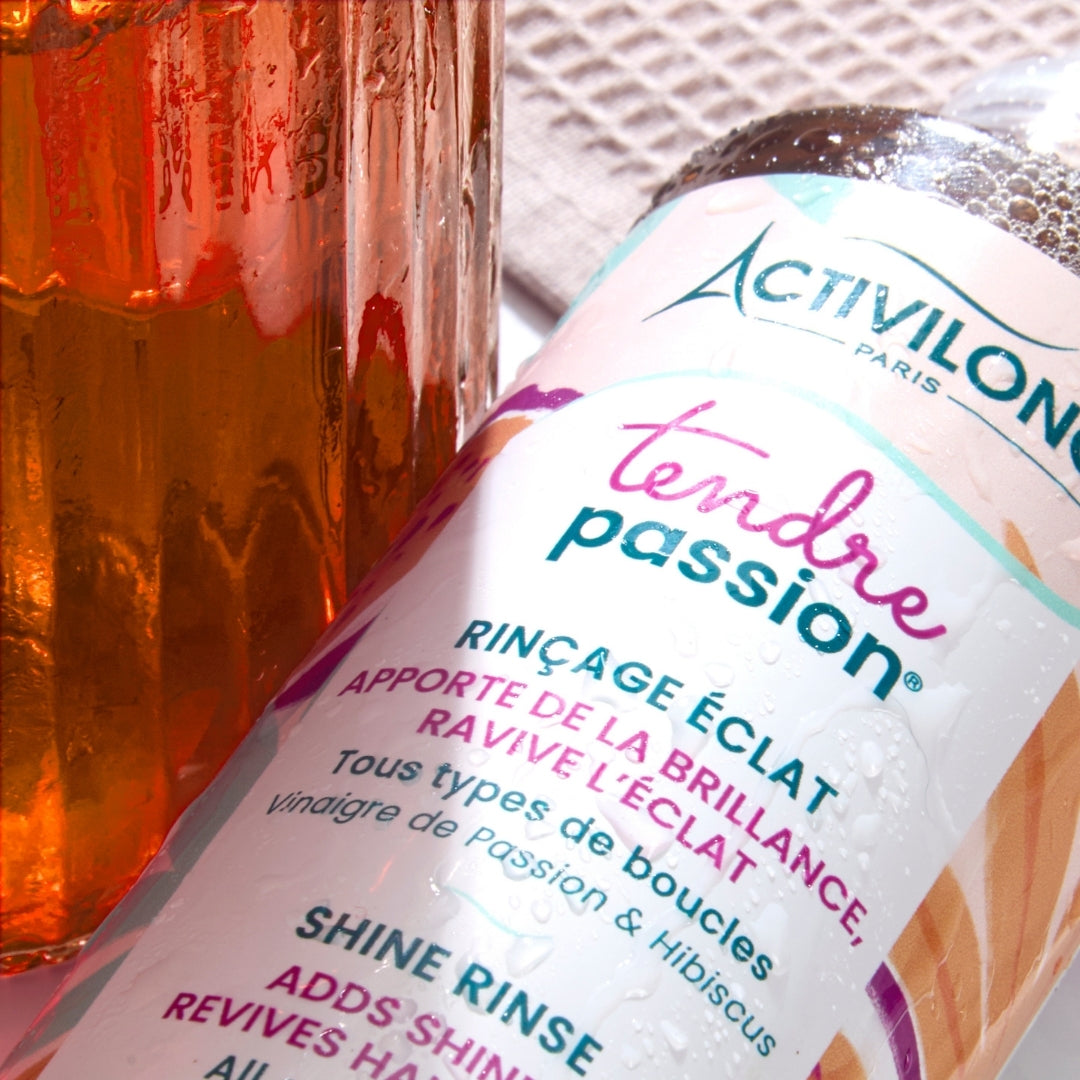 ACTIVILONG TENDRE PASSION Rinçage Éclat 250ml bottle by ABS France Wholesale with a glass of iced tea in the background