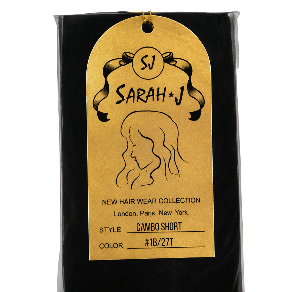 A packaged hair extension or wig sample in a black pouch with a large gold hangtag. The tag shows the brand name 'Sarah J' and reads 'New Hair Wear Collection' with style 'Cambo Short' and color '#1B/27T'.