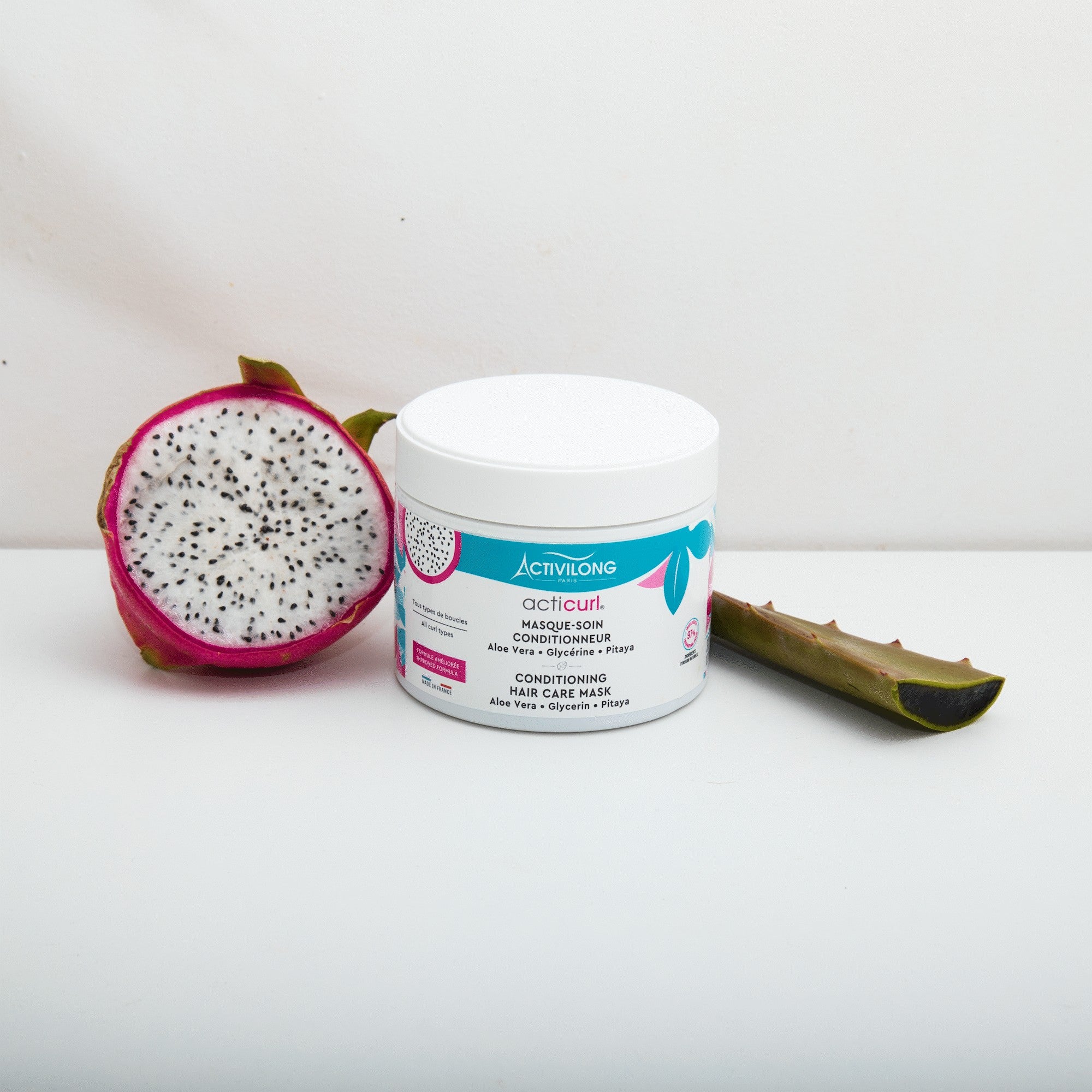 ACTIVILONG ACTICURL Masque 300ml jar by ABS France Wholesale with a half-cut dragon fruit and aloe vera leaf on a white background