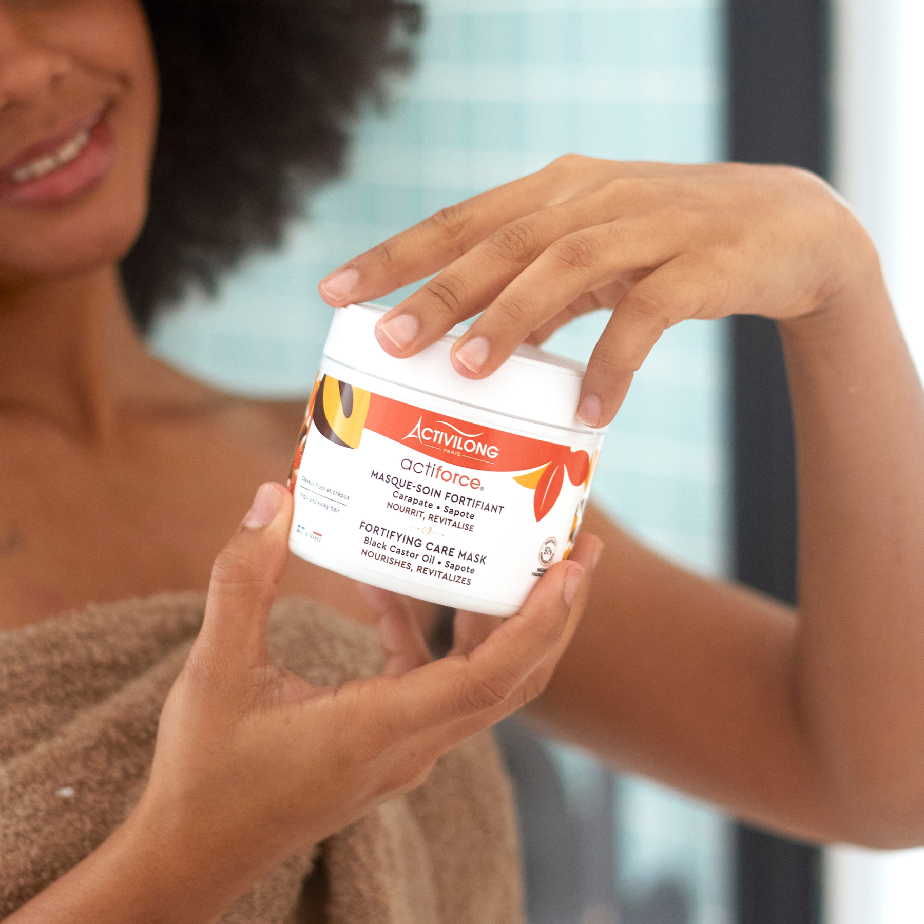 Person holding a ACTIVILONG ACTIFORCE Masque 300ml by ABS France Wholesale with a blurred background