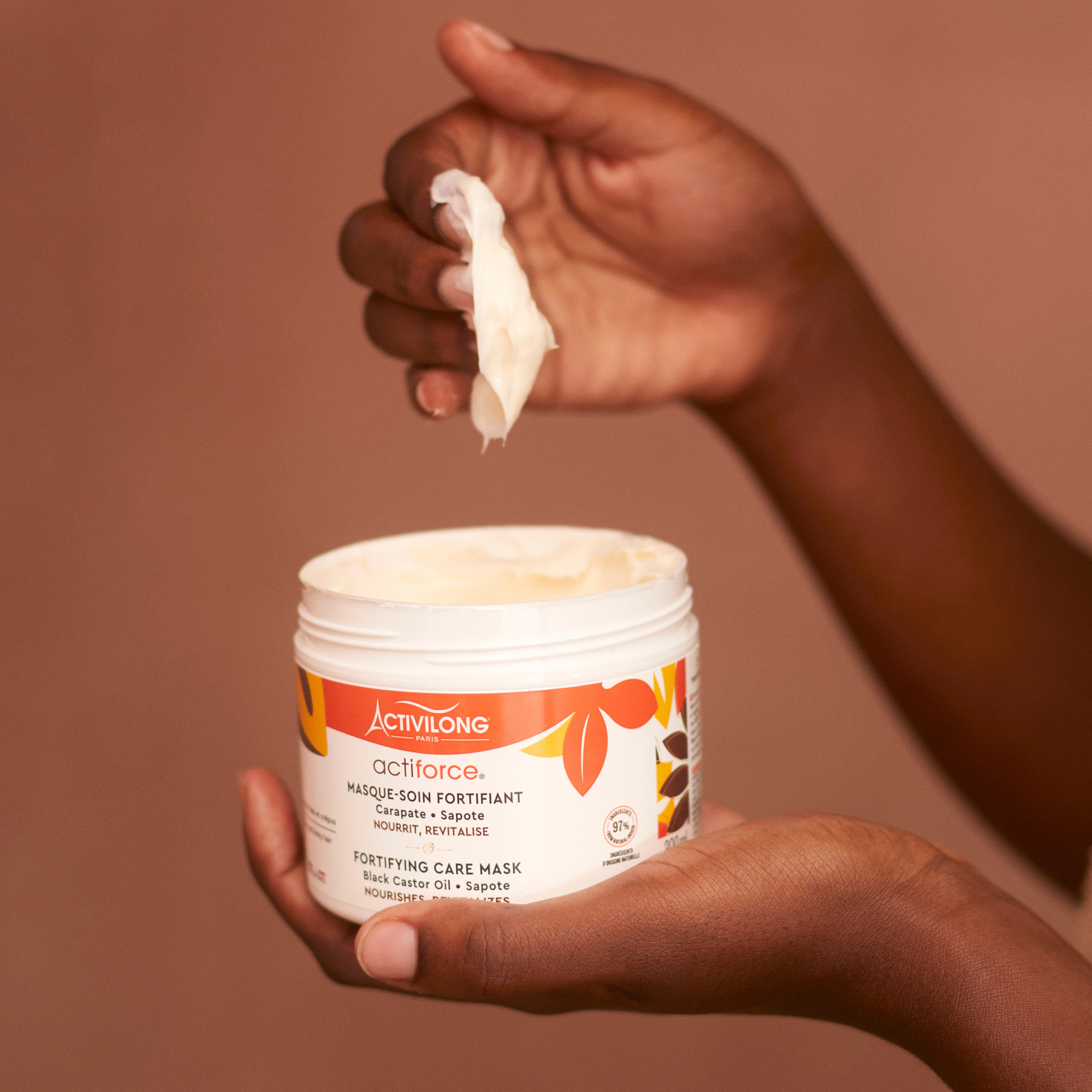 Hand holding a ACTIVILONG ACTIFORCE Masque 300ml by ABS France Wholesale with a brown background