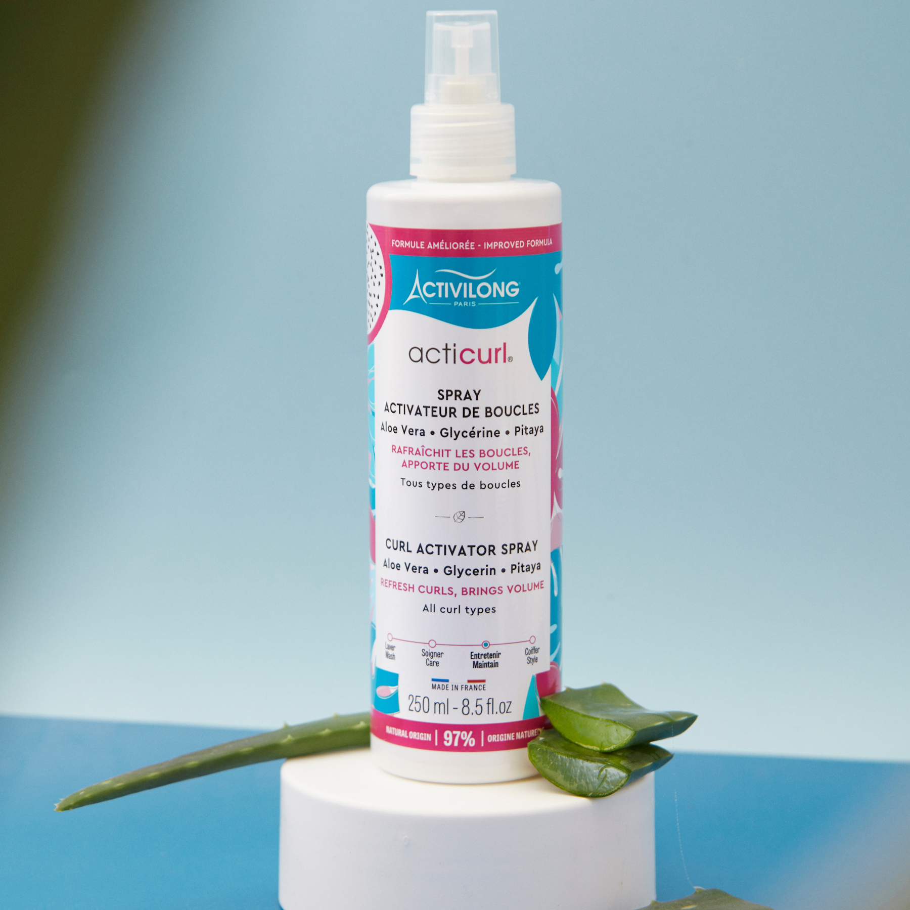 Bottle of ACTIVILONG ACTICURL Spray Activateur 250ml by ABS France Wholesale with aloe vera leaves on a blue background